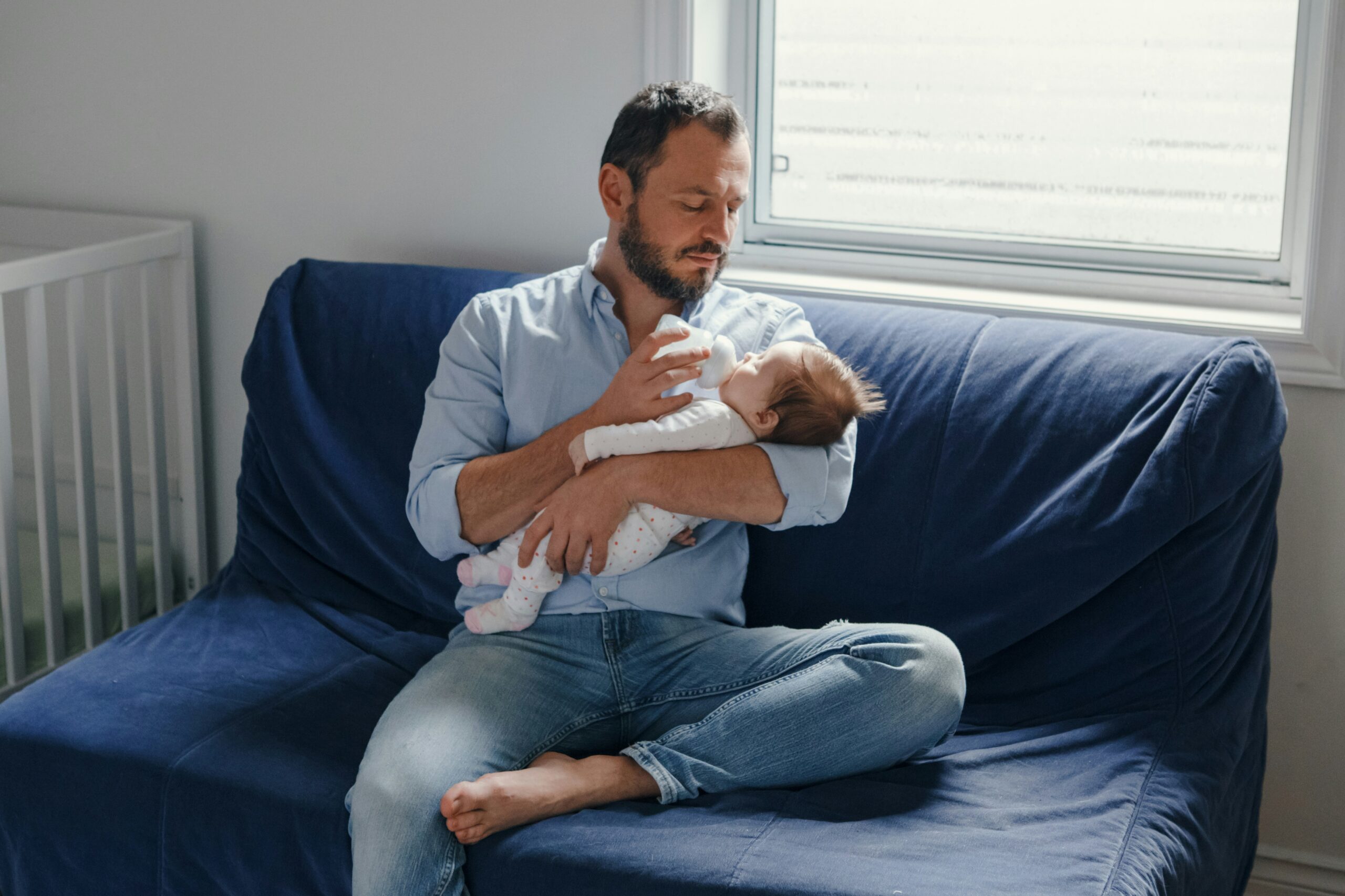 A father feeding his baby a bottle at home